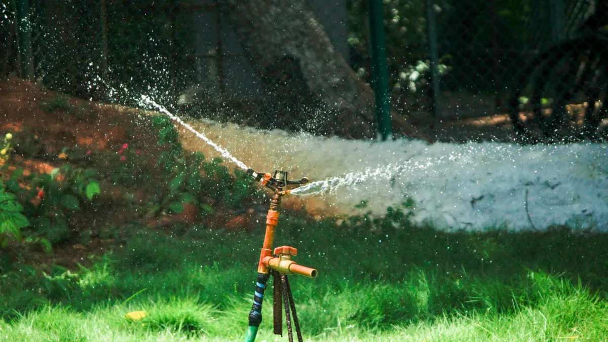 Best sprinkler setup for new sod Lawn sprinkler spraying water over grass