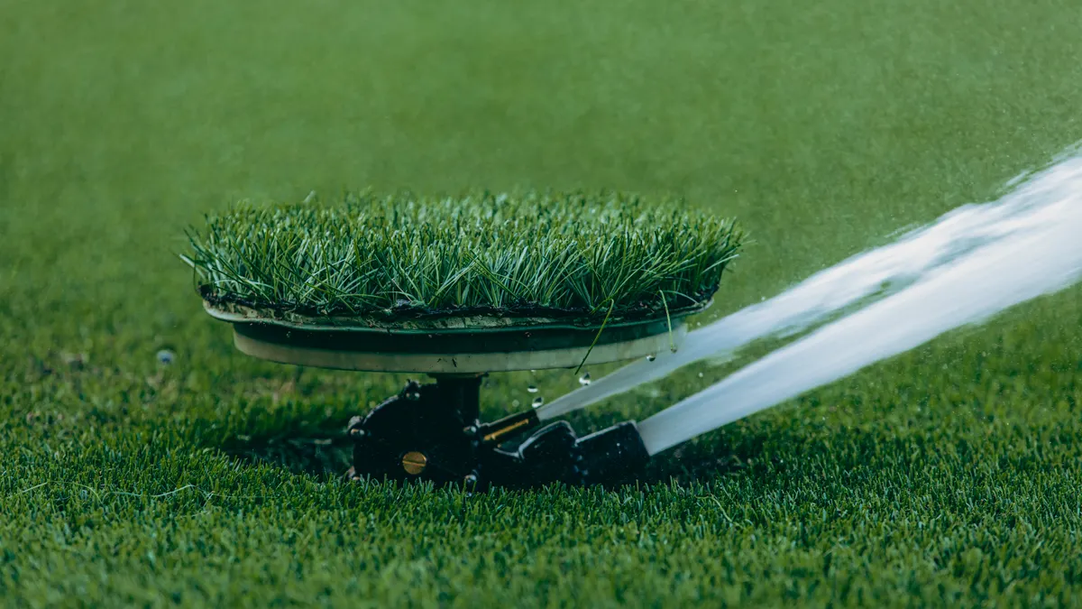 Sprinkler watering a patch of sod on a lawn